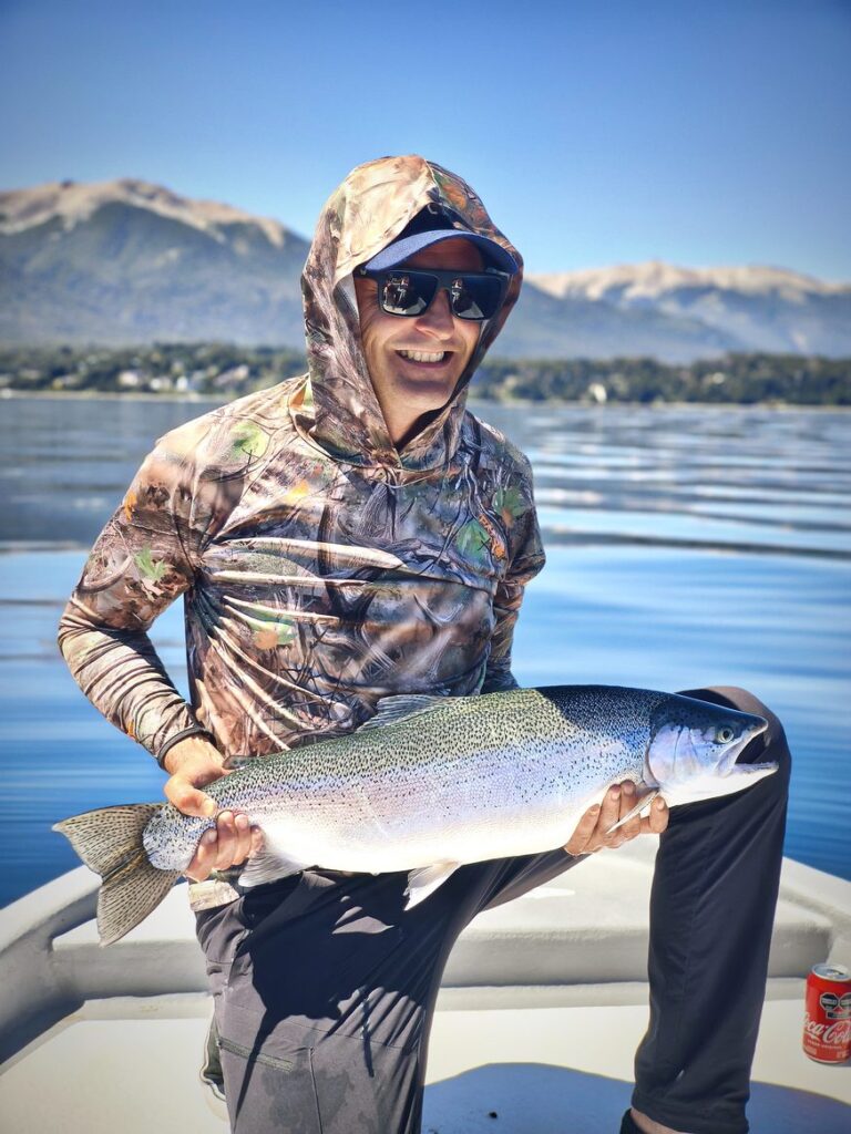 cliente con trucha en bote durante salida de día entero en Nahuel Huapi