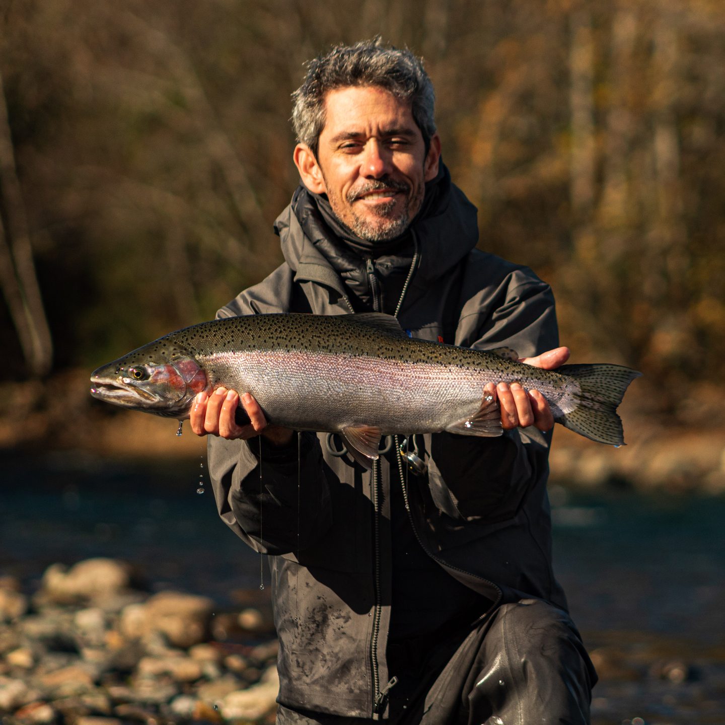 cliente con trucha arcoíris en el río Correntoso con guía de pesca